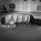 На снимке первые движения мальчика с шейным уровнем травмы позволяют сделать куски картонной трубы, на который был намотан линолеум.